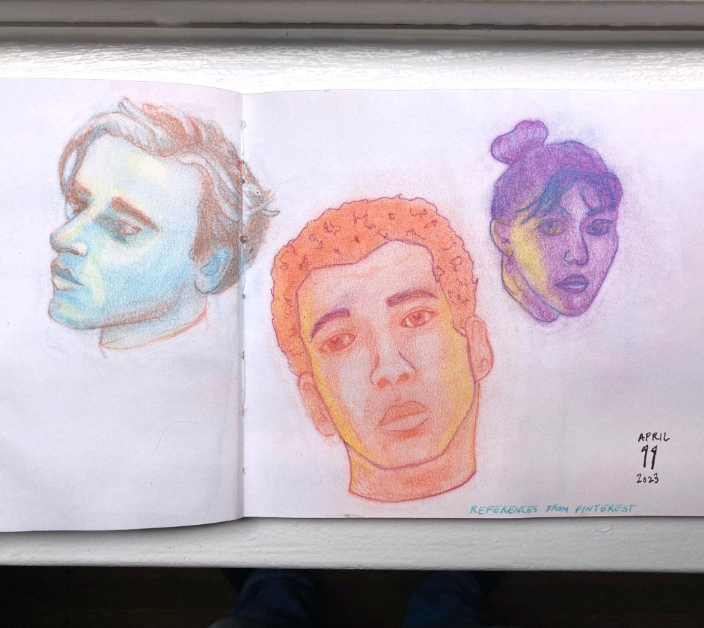 Three faces sketched in colored pencil in blue, yellow, orange, and purple.