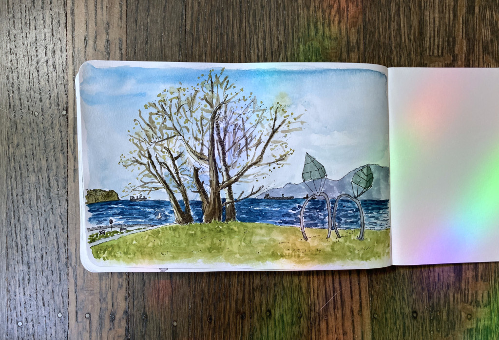 A watercolor sketch of a large tree and a sculpture of two diamond engagement rings embedded in the grass, overlooking the ocean