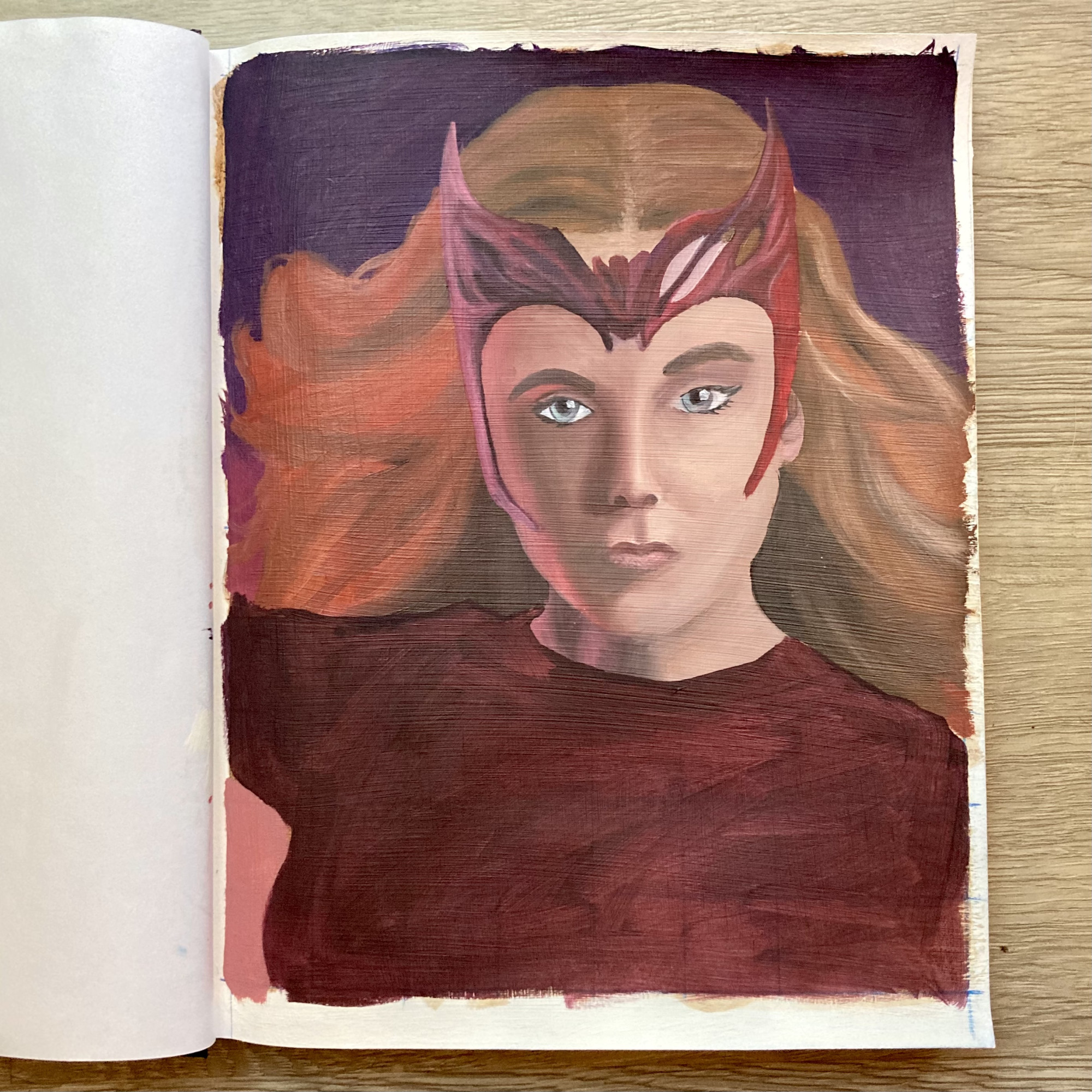 A painting of the Marvel character Scarlet Witch, partially unfinished, in a sketchbook